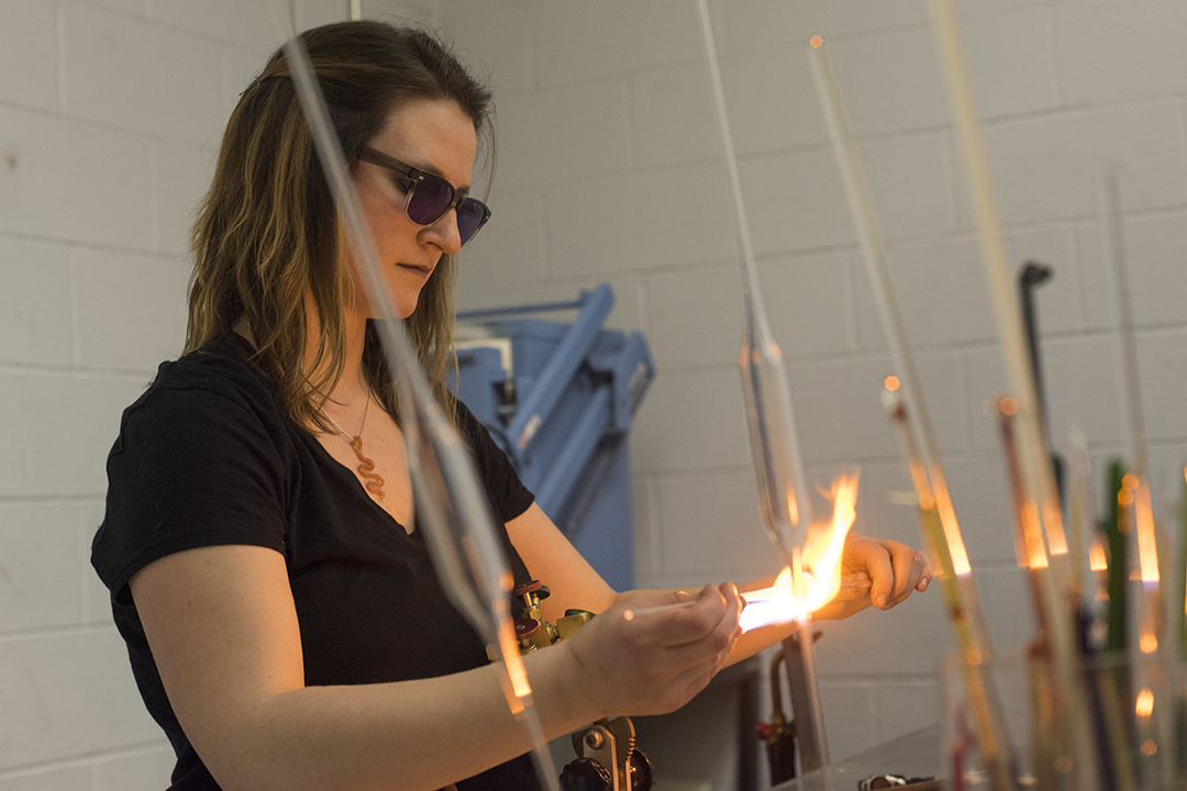 Madeline Rile Smith works in the flame working studio.