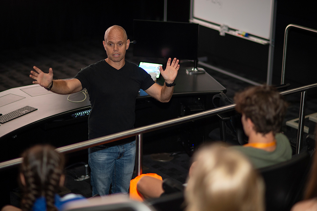 professor speaking to students in a studio.