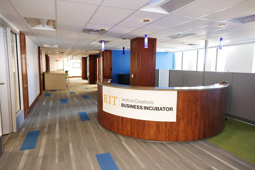 reception desk in an office area with a sign that reads: RIT Venture Creations Business Incubator.