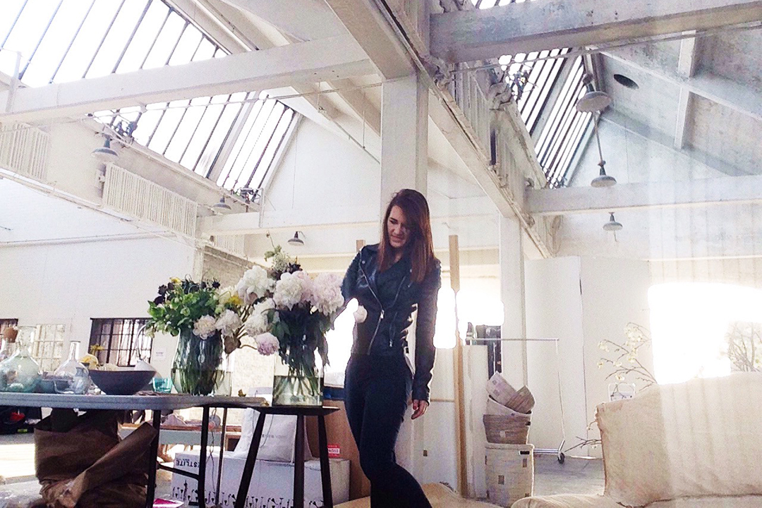 Michelle Bablitz adjusts flowers on the table of a photo shoot set.