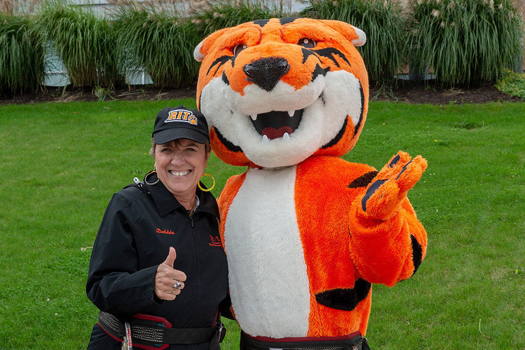 woman posing with tiger mascot.