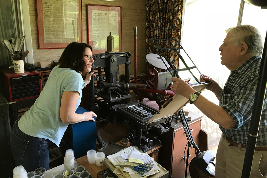 two people looking at a historic printing press.