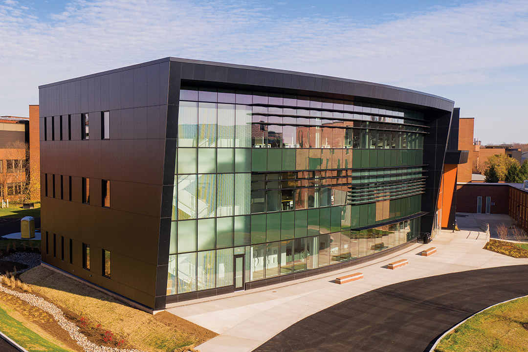 exterior of three-story black building with glass window front.