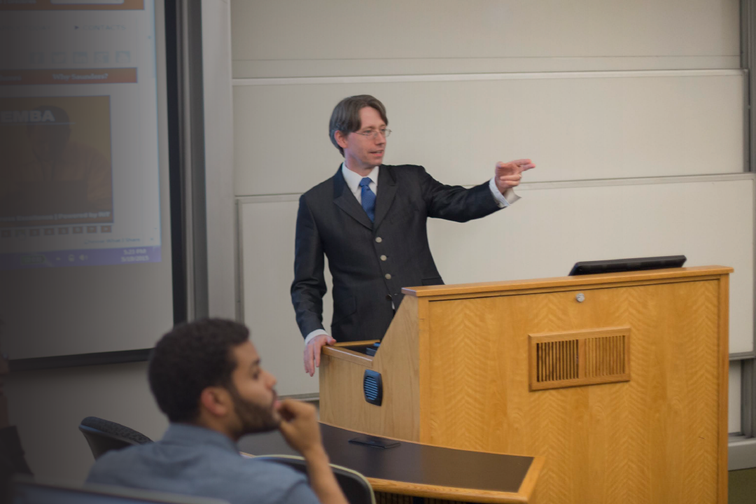 A Saunders professor teaches his class in a learning hall.