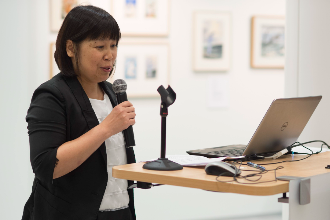 Professor Jerrie Hsieh speaks into a microphone at Saunders College of Business