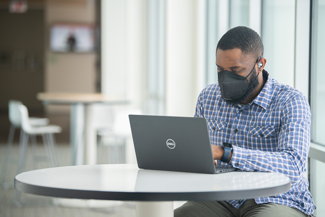 person wearing a hearing aid using a laptop computer.