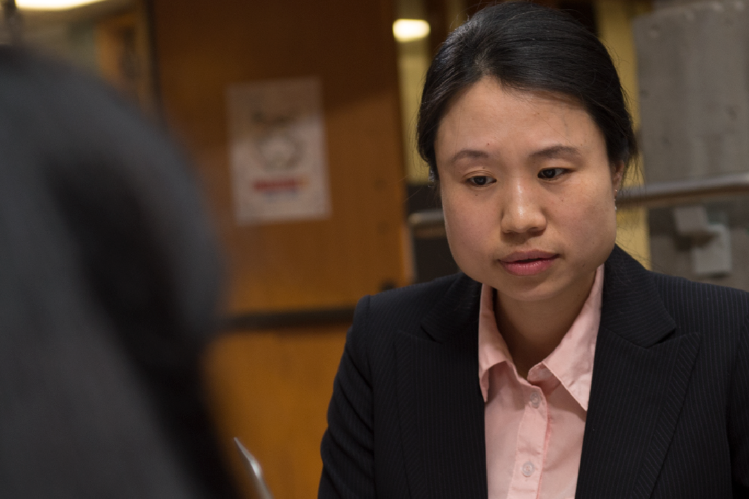 Professor Qian Song converses with a student at Saunders College of Business