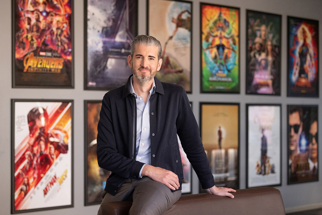 person posing in front of movie posters.