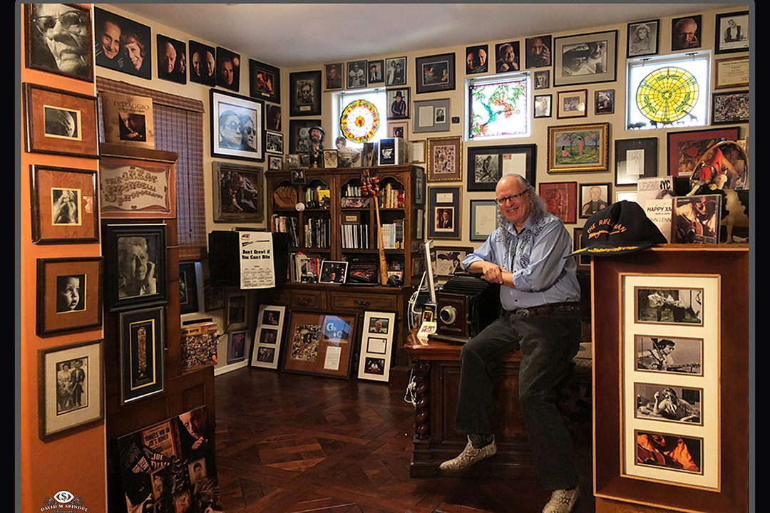 man sitting in office full of photos of celebrities.