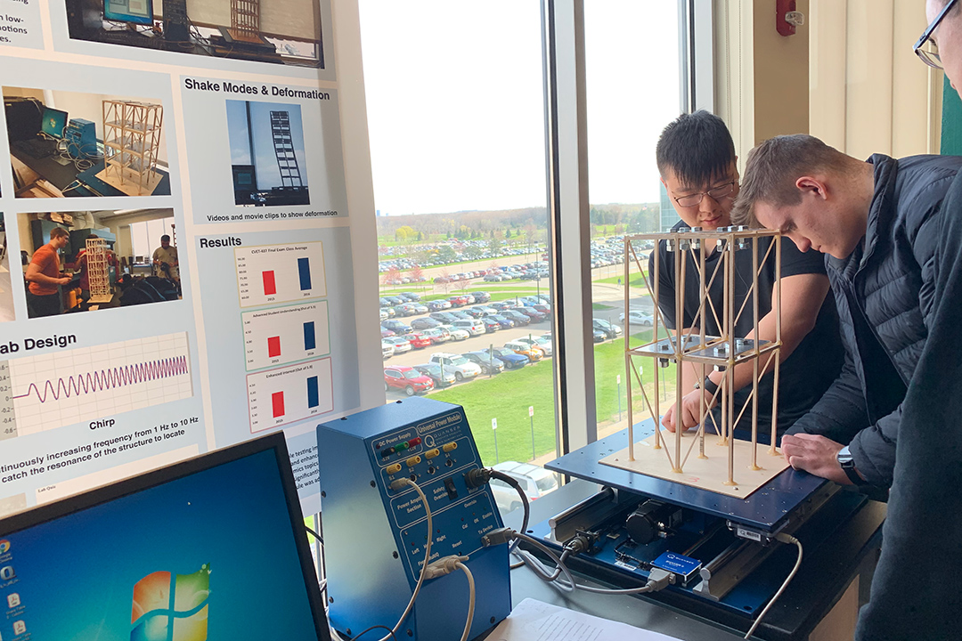 students testing a model structure on equipment to test how it withstands shaking.