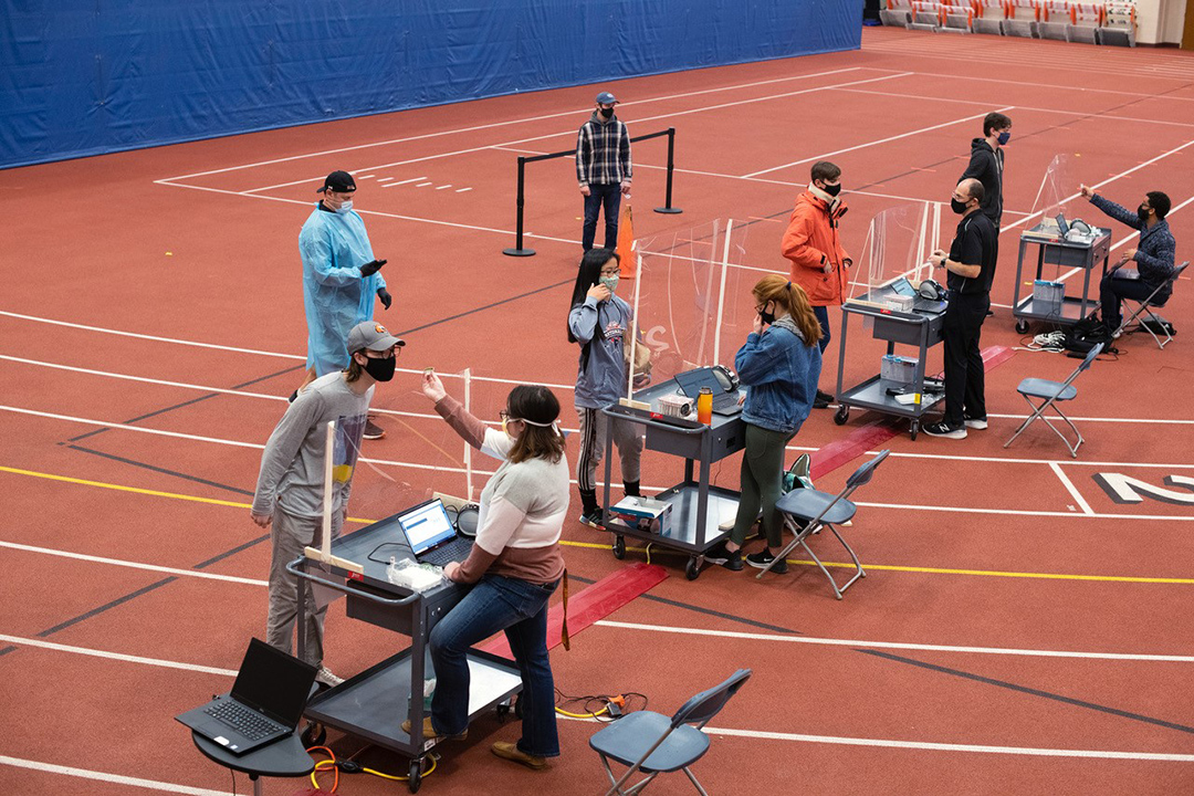 students at individual stations receiving a nasal swab.