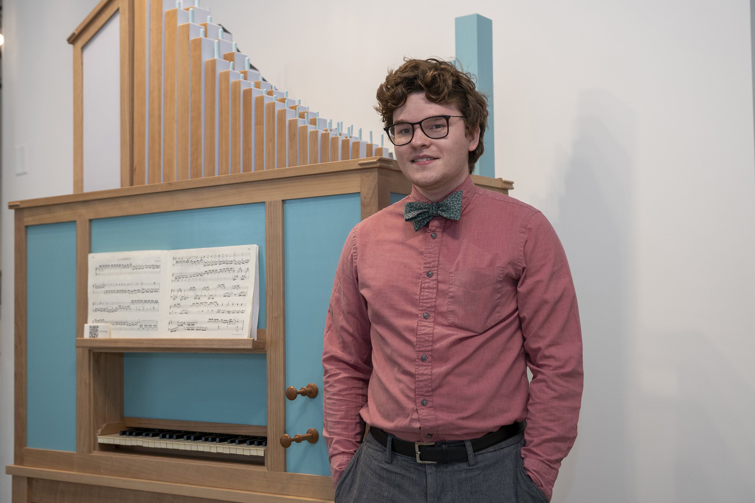 Kelly Cleveland stands next to the pipe organ he custom built.