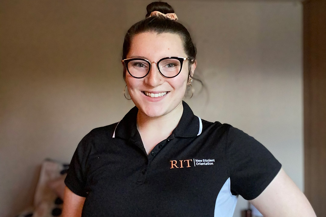 student wearing RIT New Student Orientation polo shirt.