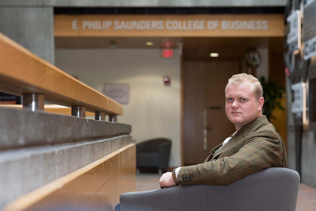 Portrait of Chance Wright sitting in the lobby of Saunders College of Business.