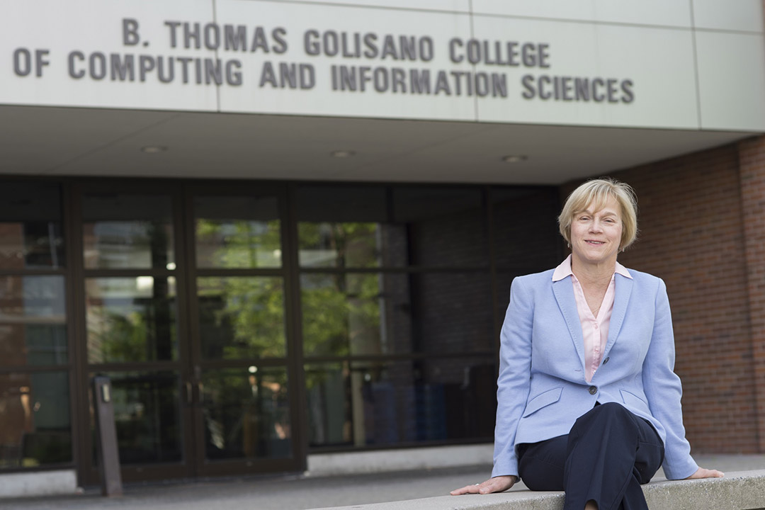 GCCIS dean sitting outside of the computing college building.