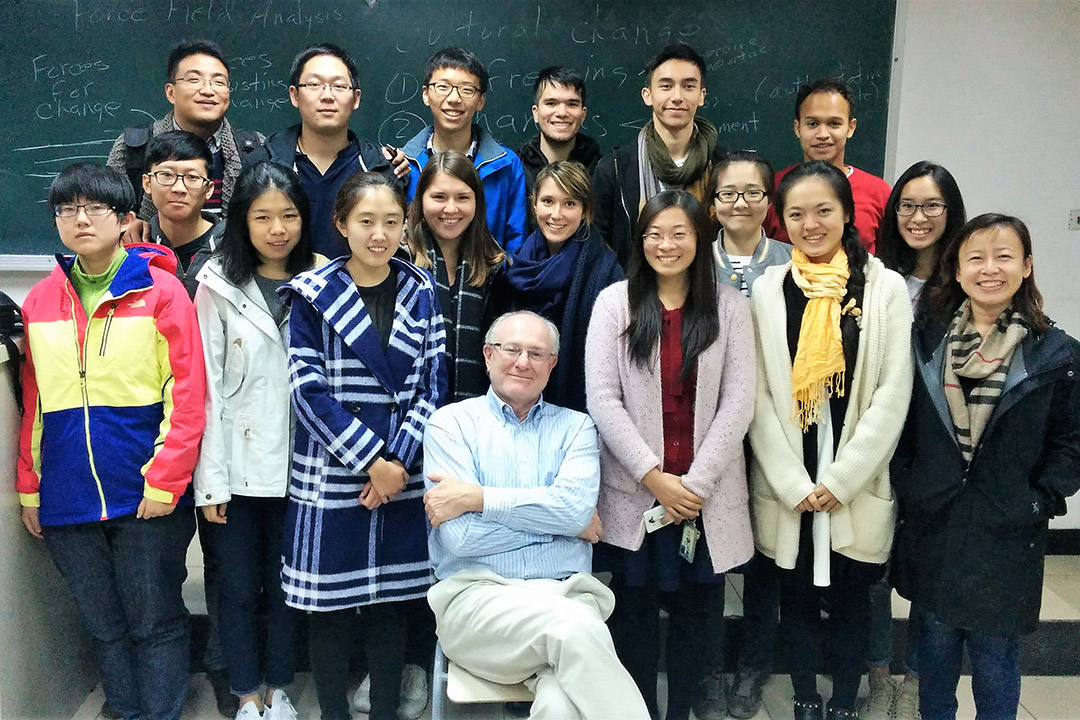 professor sitting with group of students in Beijing.