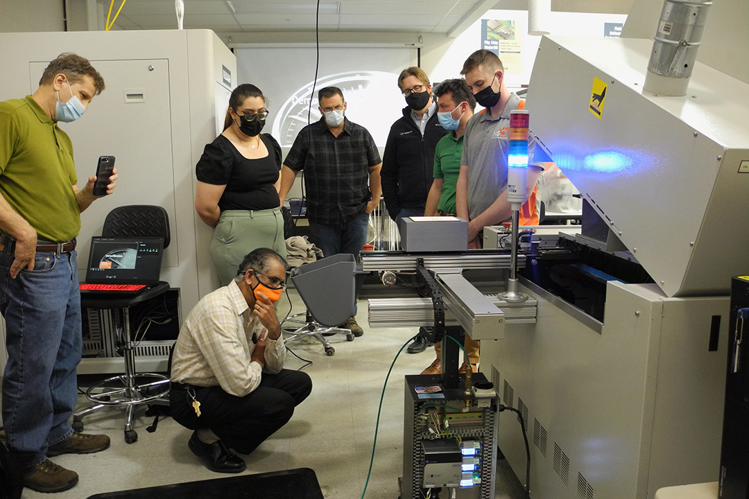 students and faculty looking at an industrial convection reflow oven.