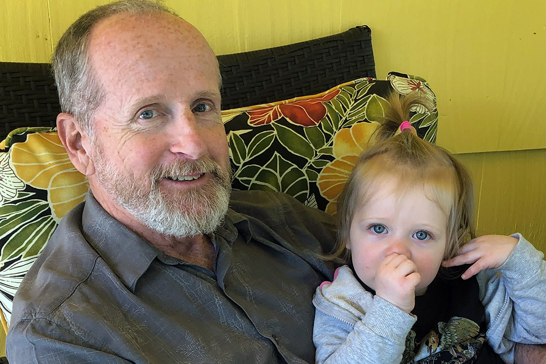 professor sitting with toddler granddaughter.