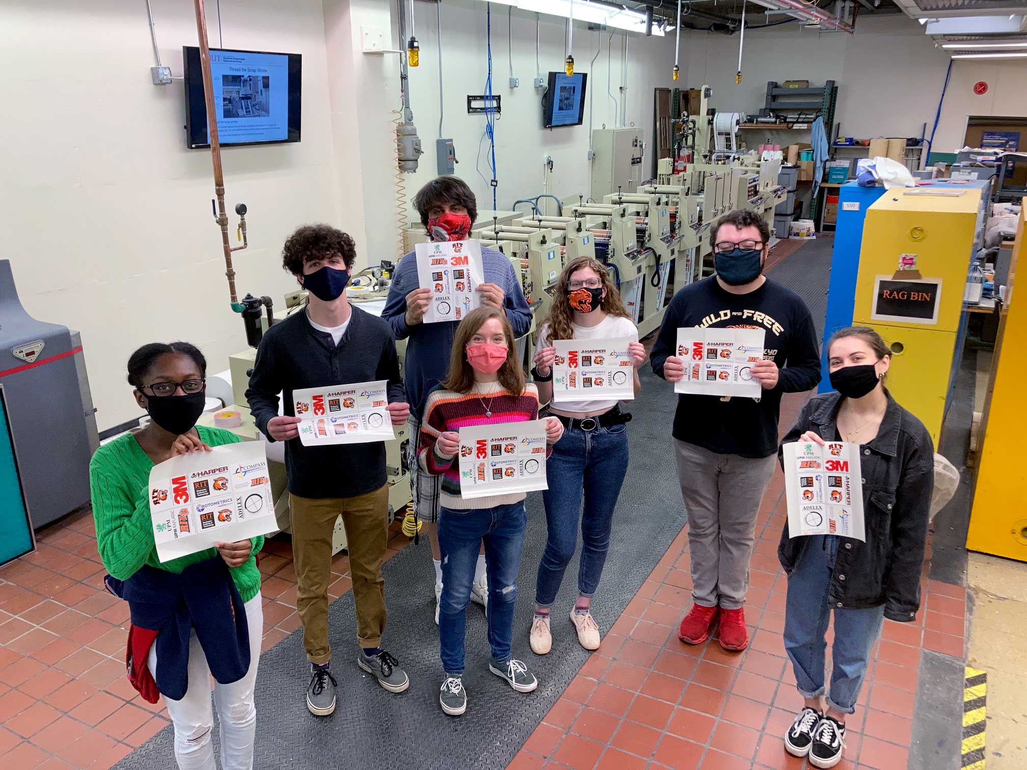 Students holding flexographic labels printed during "Recognition Run"