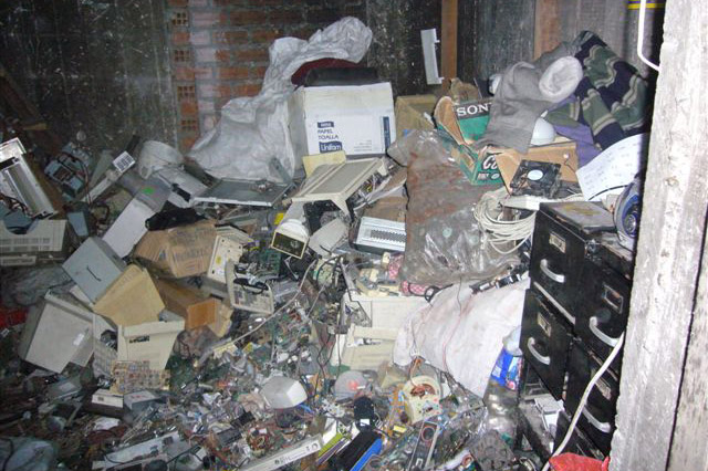mounds of electronic garbage piled up in a room.