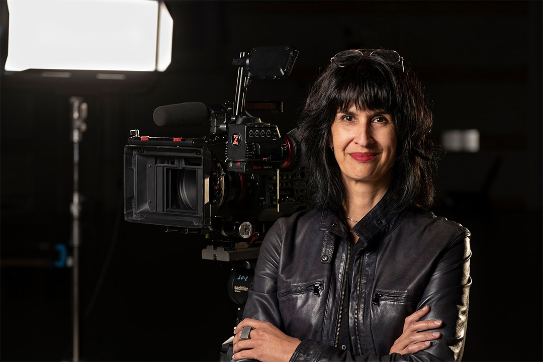 filmmaker Shanti Thakur posing with a camera.