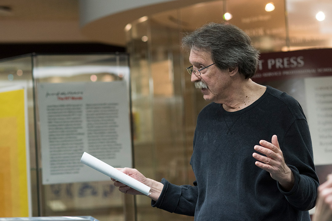 man holding paper and giving a presentation.