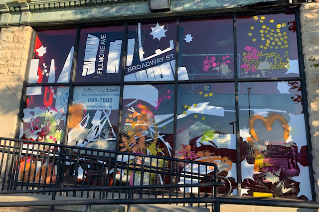 A storefront window display of abstract painting and printmaking.