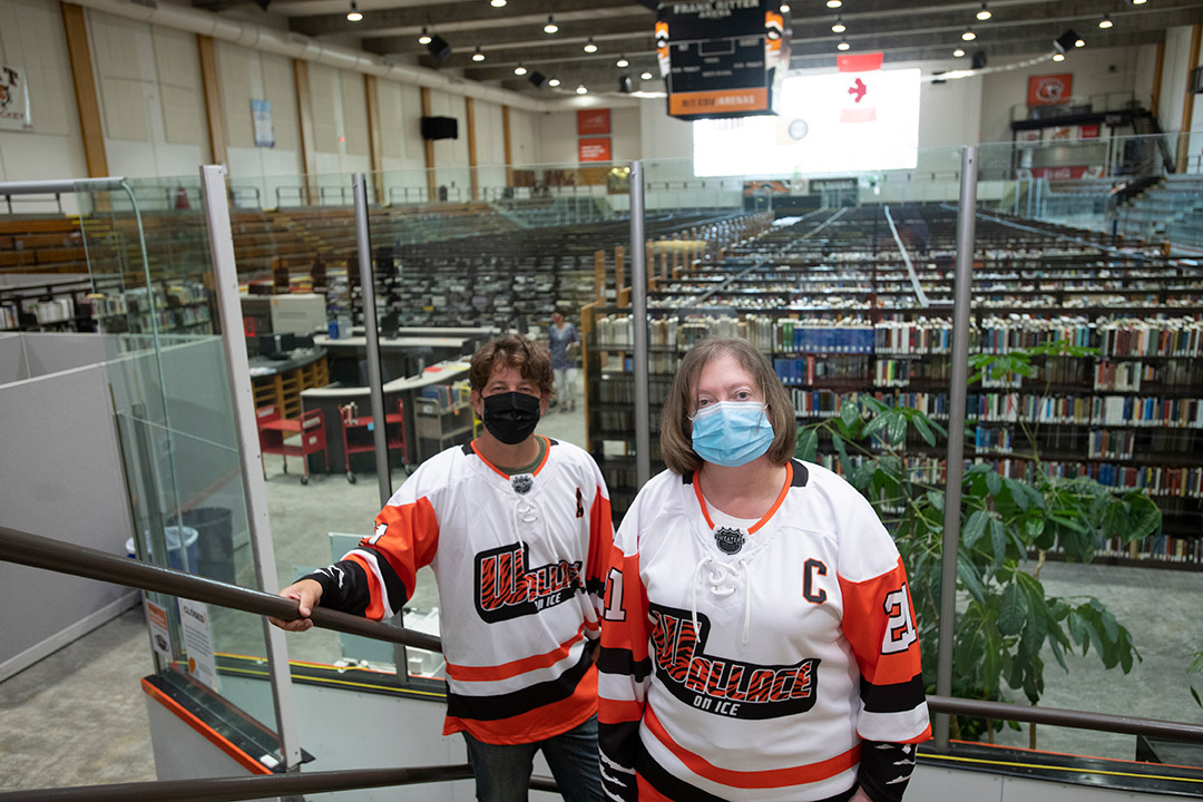 library staff wearing custom hockey jerseys in an ice arena that has been converted to library space.