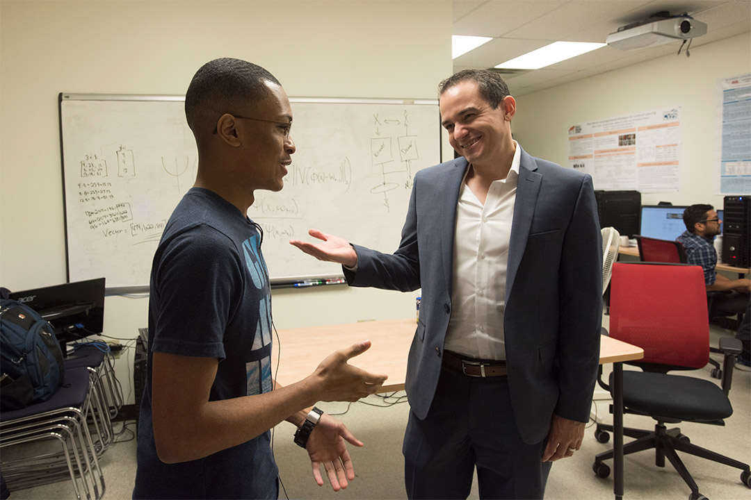 professor talking with student in a lab.