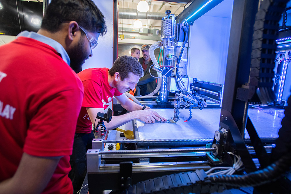 professor and student work on a 3D printer.