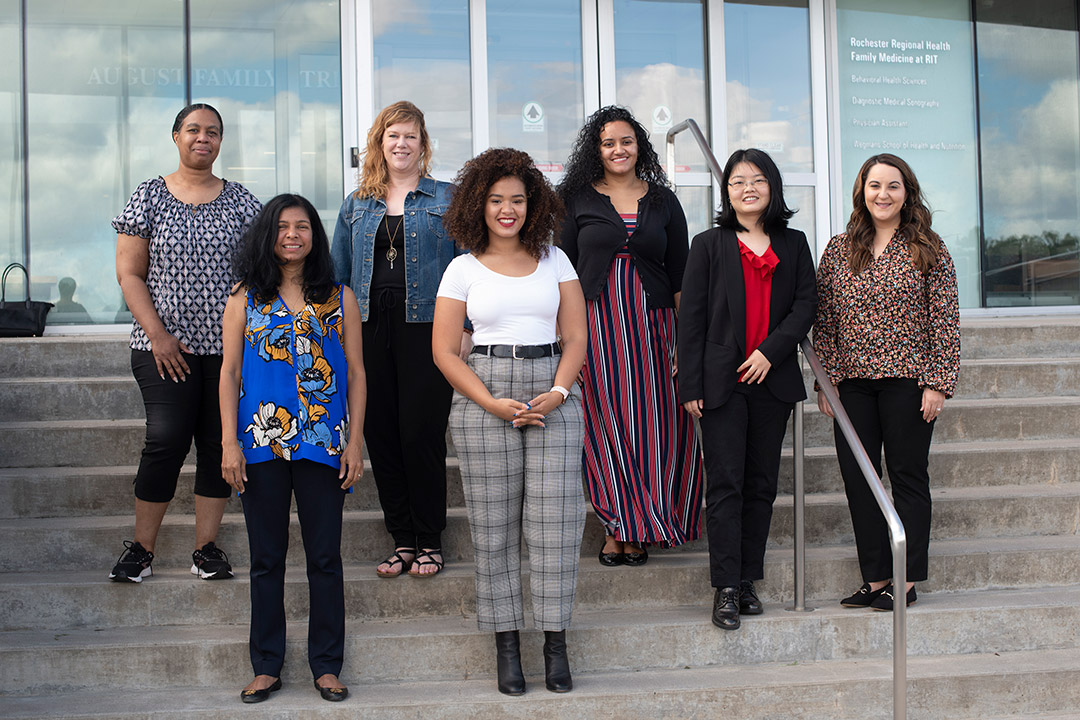 group of seven women standing on steps outdoors.