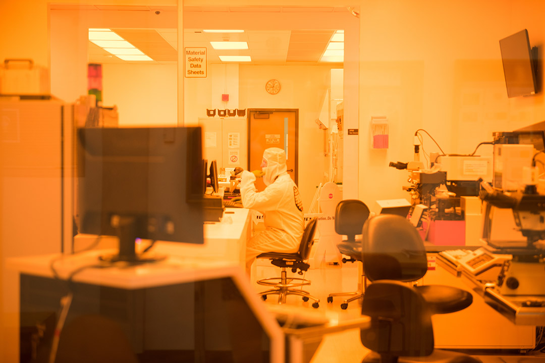 person in a full clean suit sitting in a clean room.