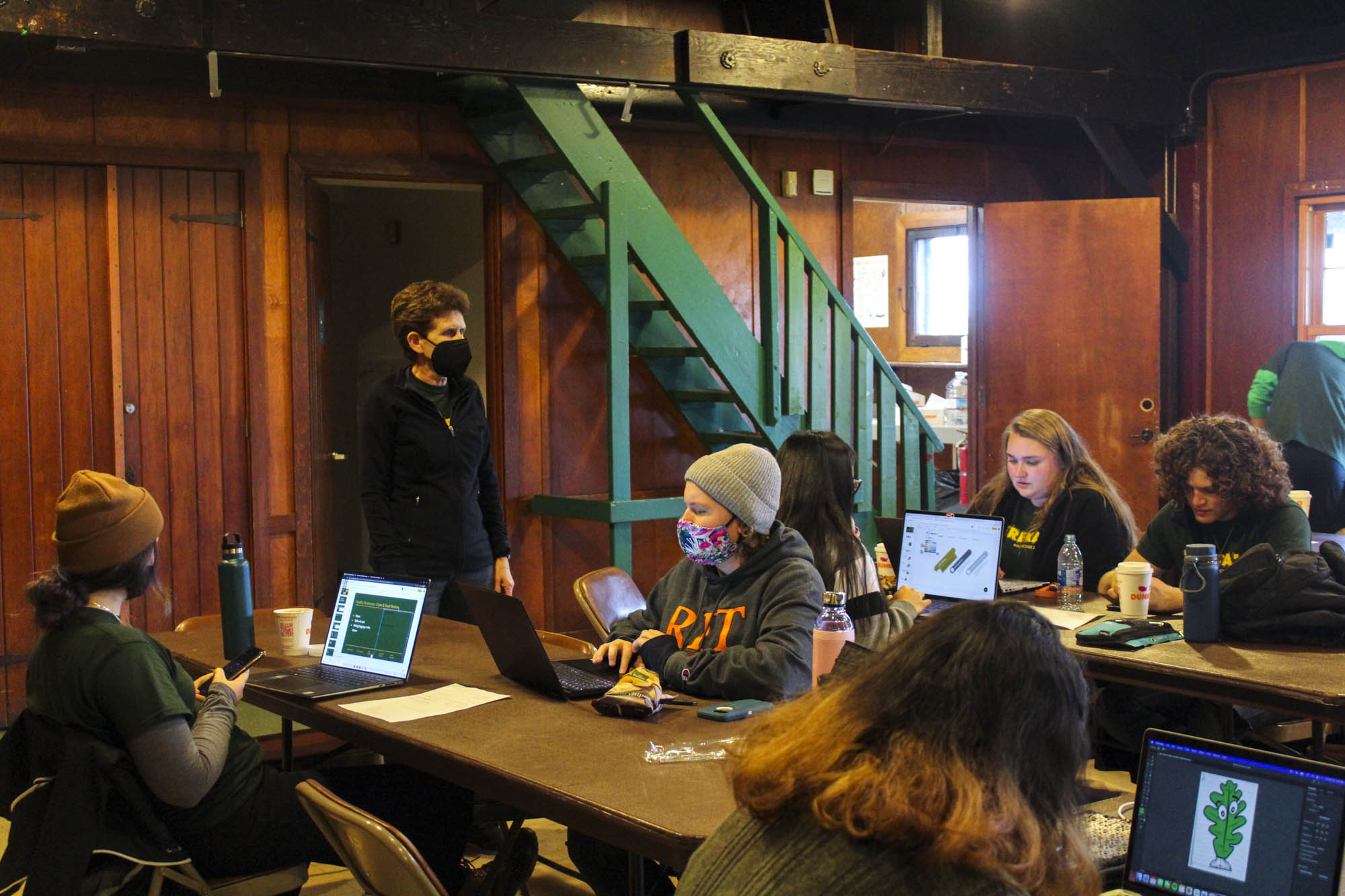 Students work on computers in a park lodge.
