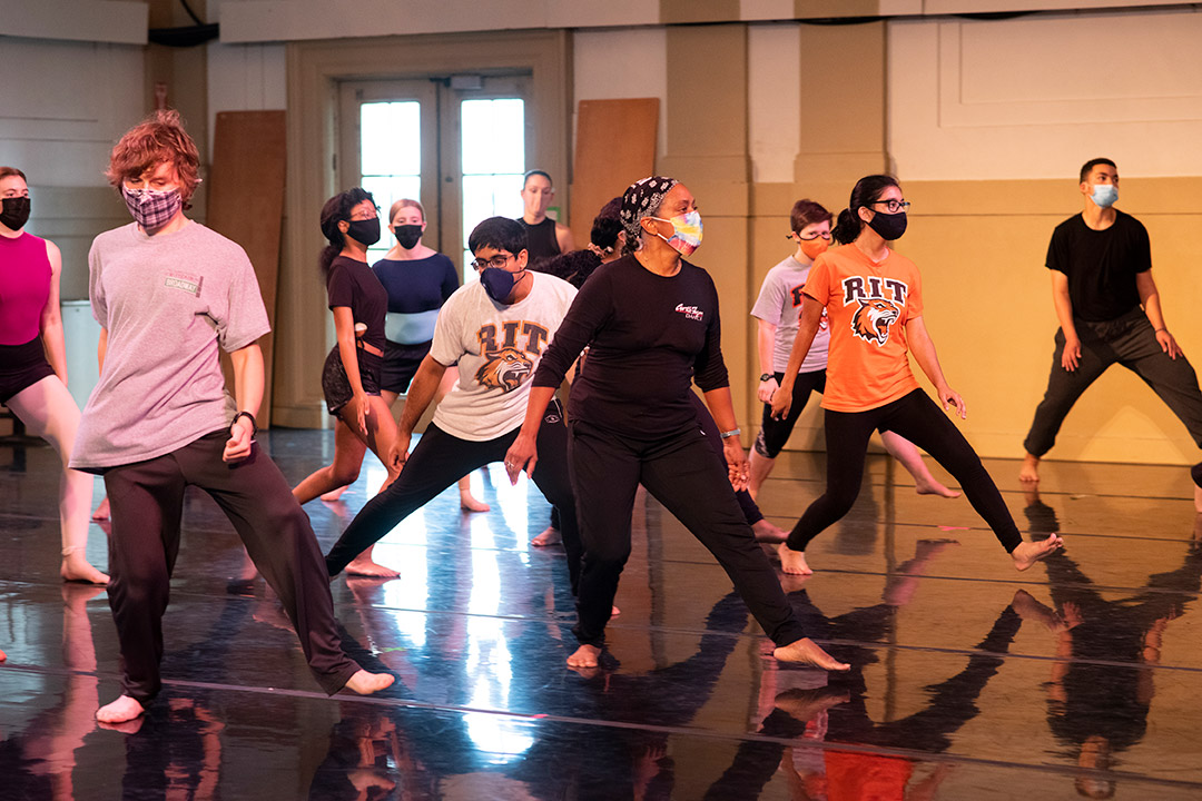 group of masked people learning a dance.