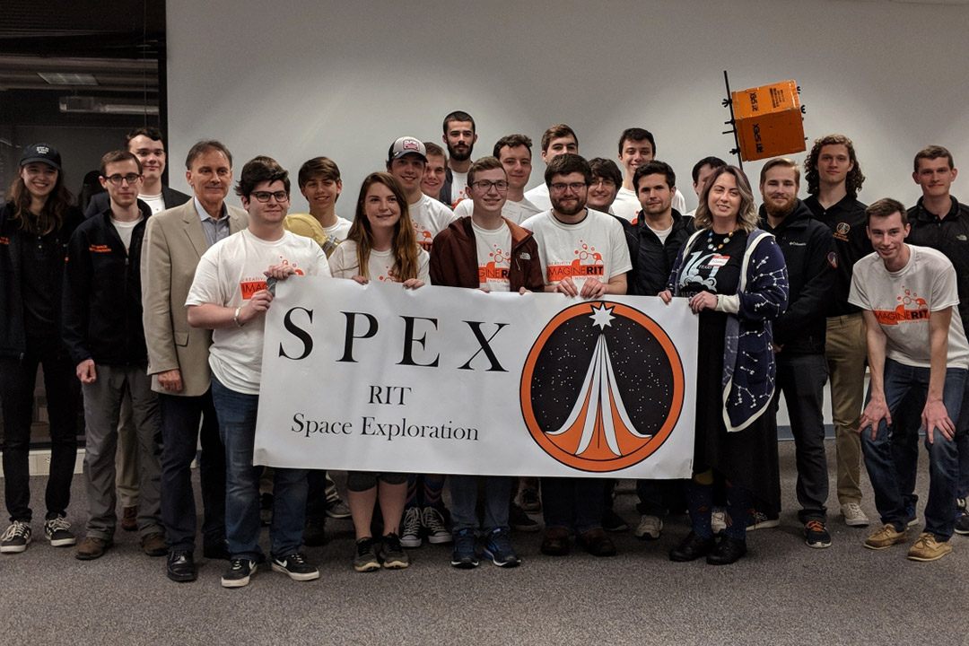 group of students holding a banner that reads: SPEX RIT space exploration.