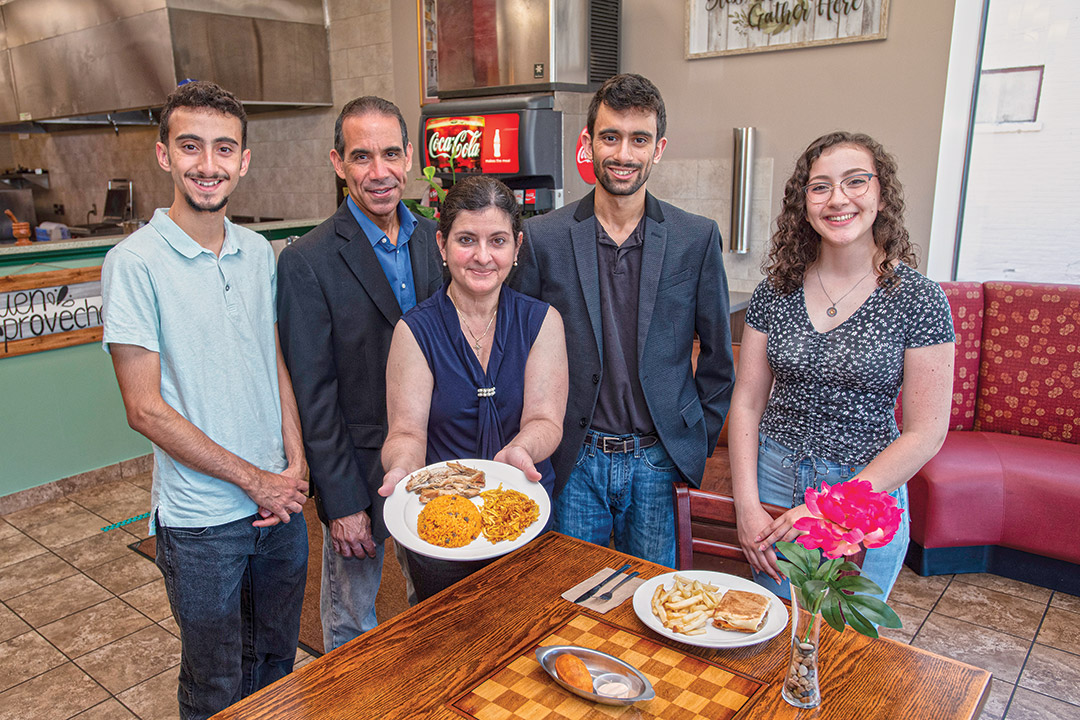 family of five standing in a restaurant.