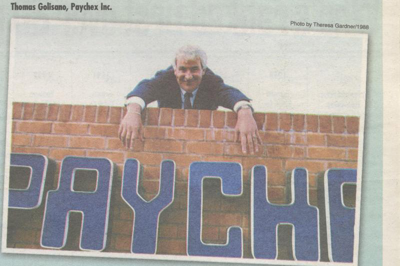 A newspaper clipping of a 1988 issue of the Rochester Business Journal featuring Tom Golisano and the Paychex sign. 