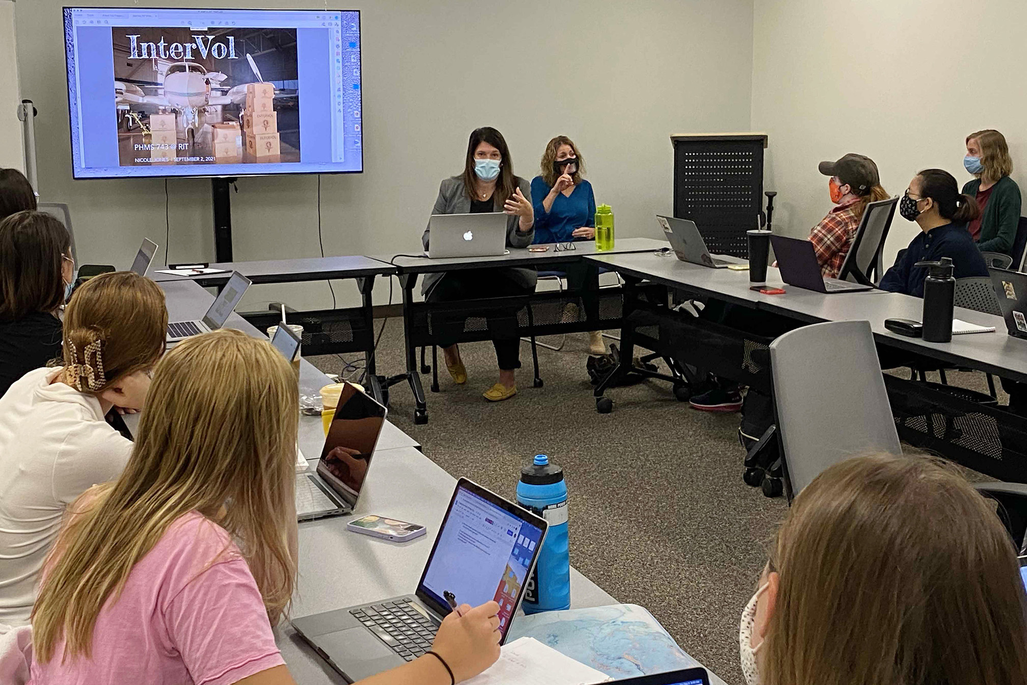 A speaker gives a presentation to a class. 