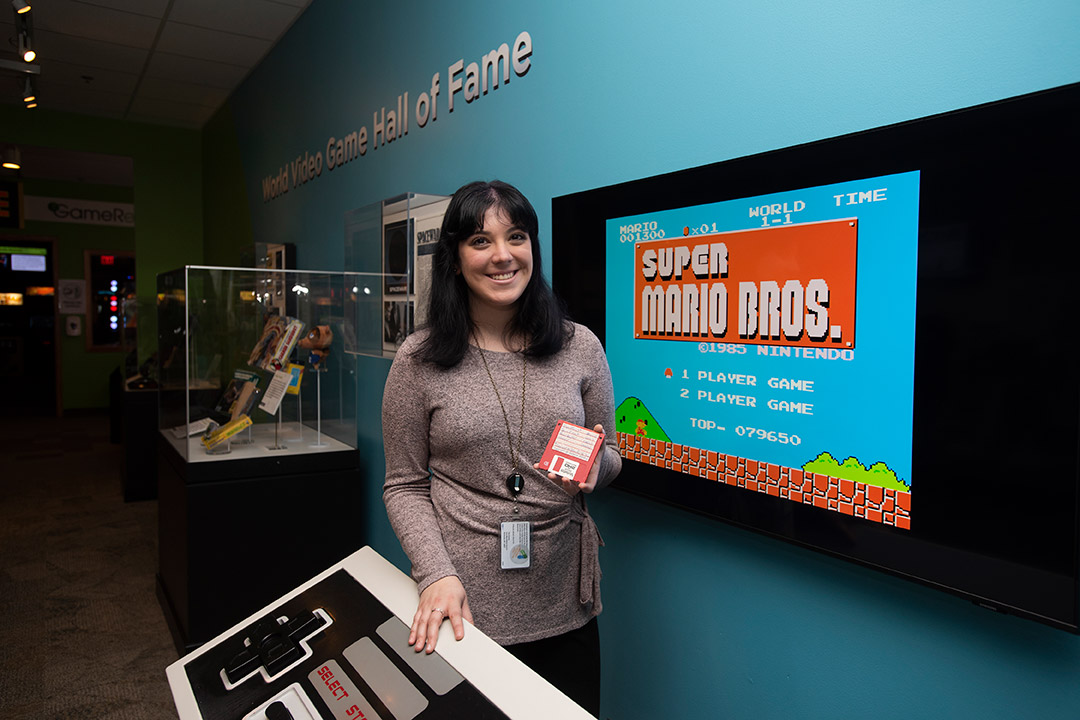 person stadning in front of a TV screen with the Super Mario Bros. opening scene.