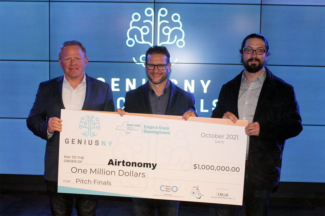 three people holding a giant novelty check for one million dollars.