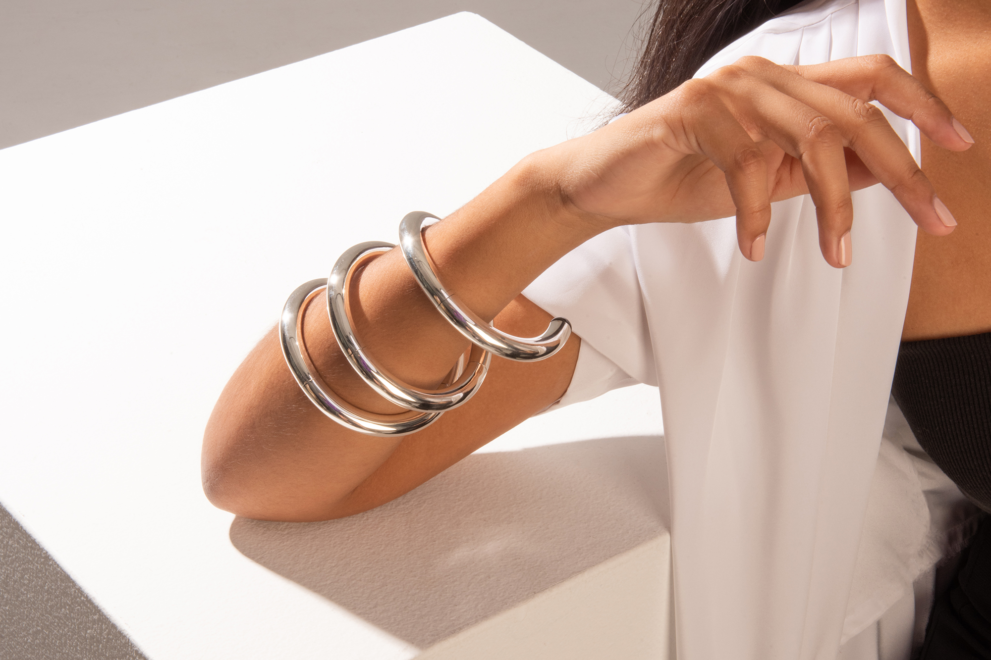 A silver bracelet sits on the wrist of a model.