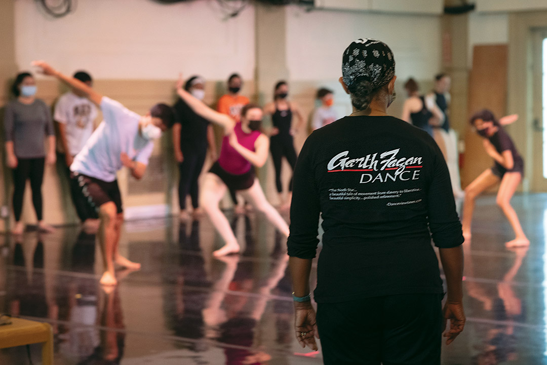 dance instructor looks on as students practice.