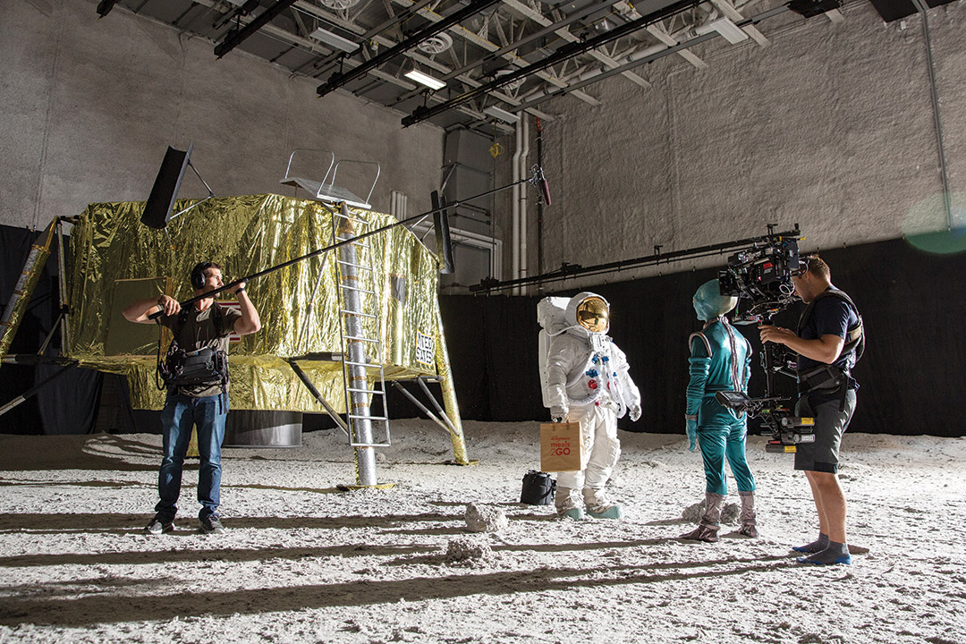 film crew shooting a scene with an astronaut meeting an alien on the moon.