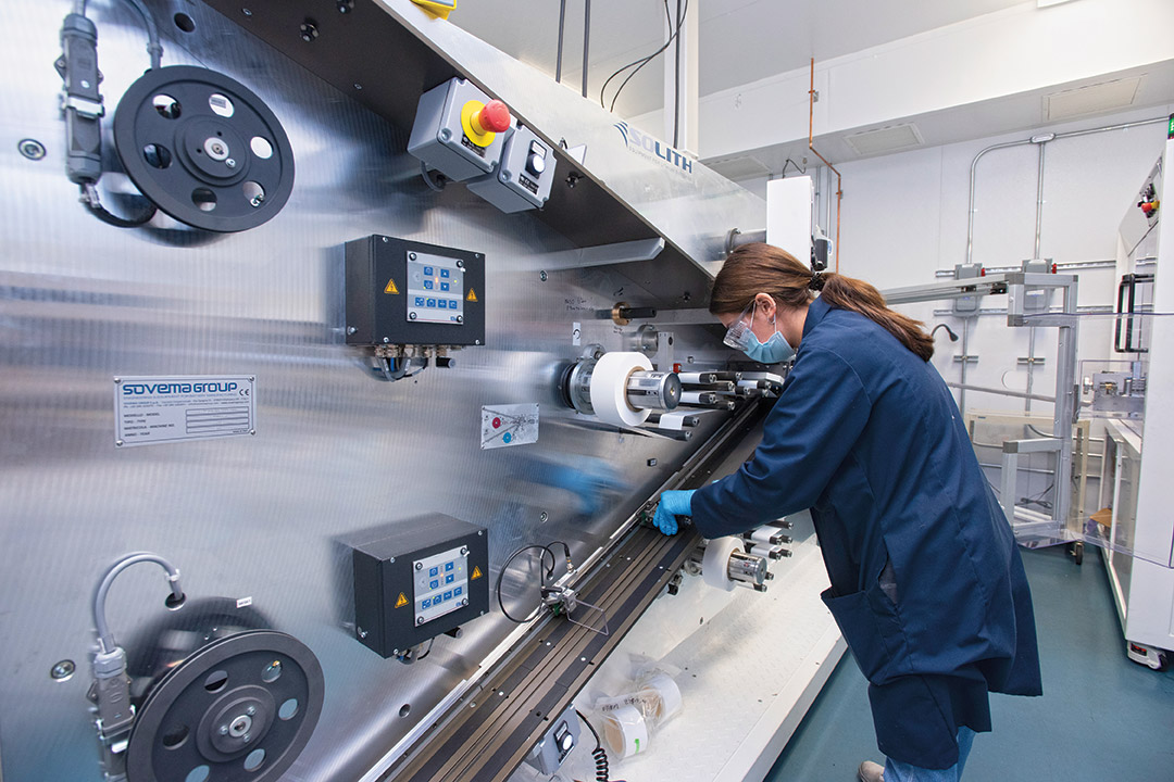 student researcher adjusts equipment that makes batteries.