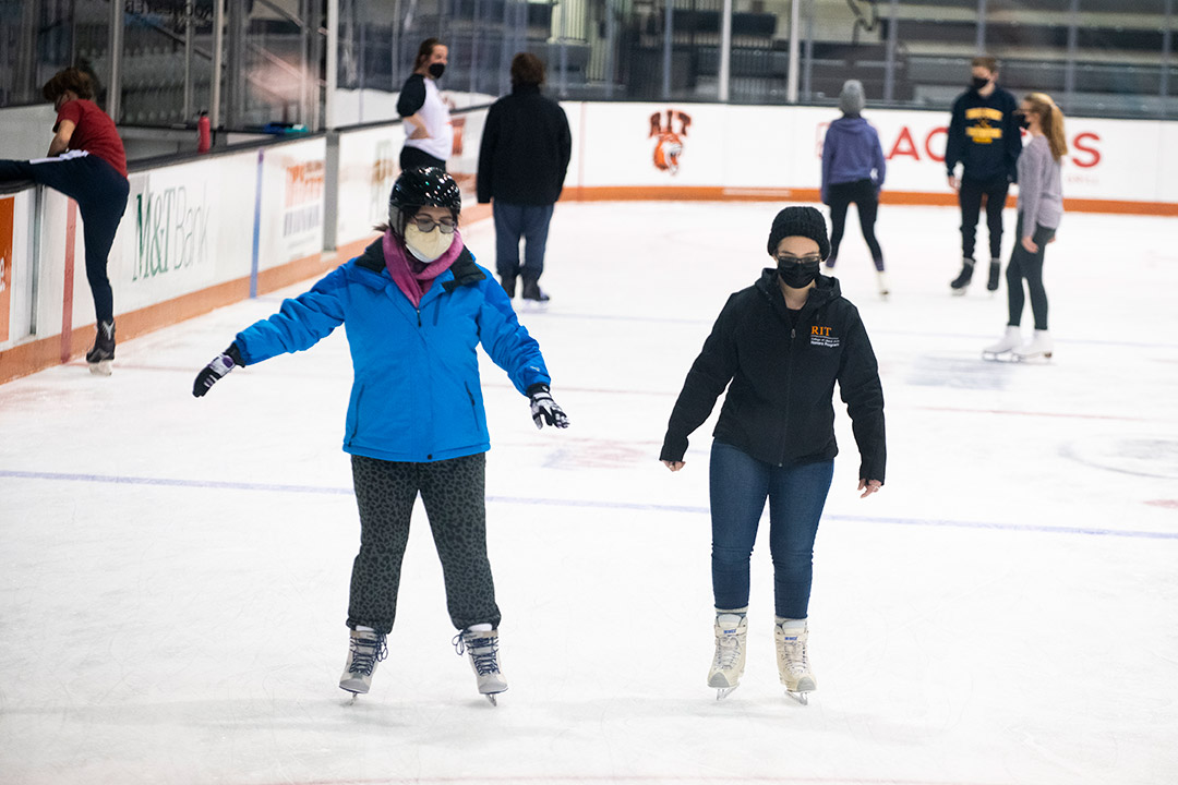 students ice skating in the Gene Polisseni Center.