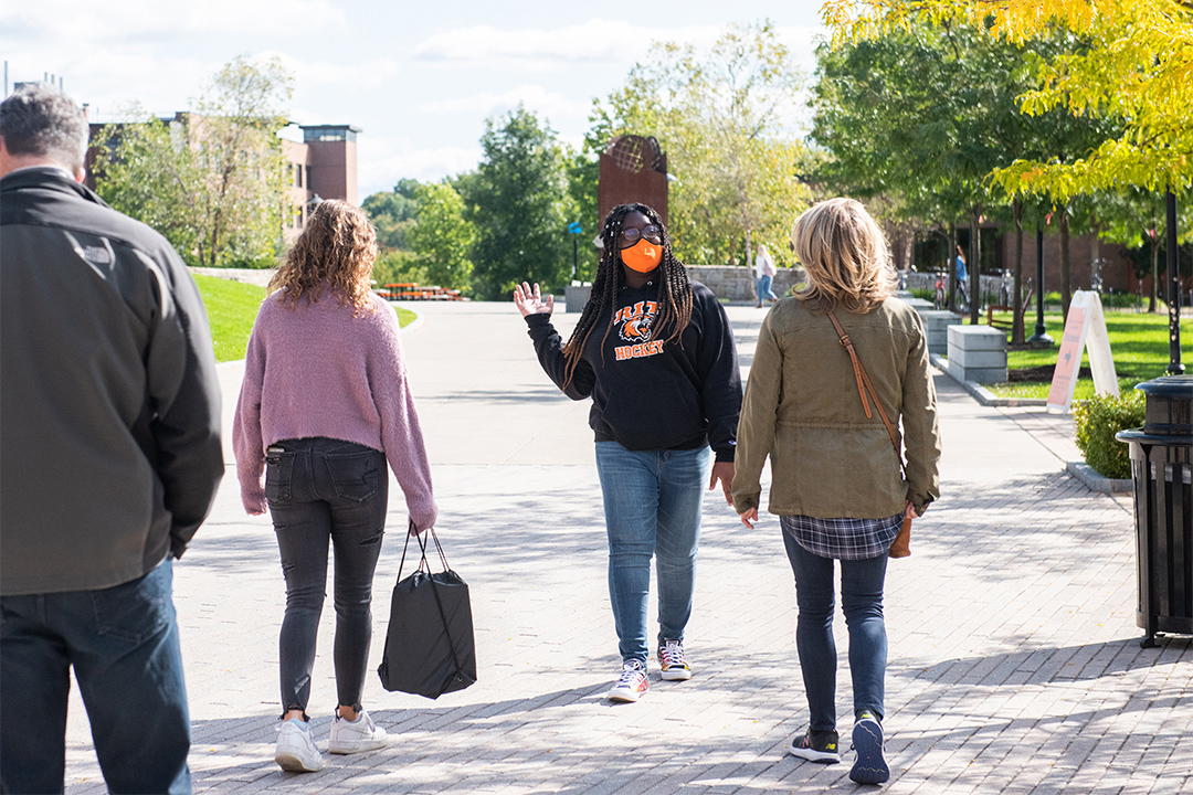 student walking backwards giving a tour of the RIT campus.