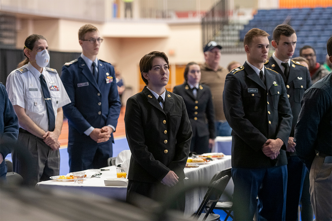 members of the various branches of the U.S. military standing during a breakfast.