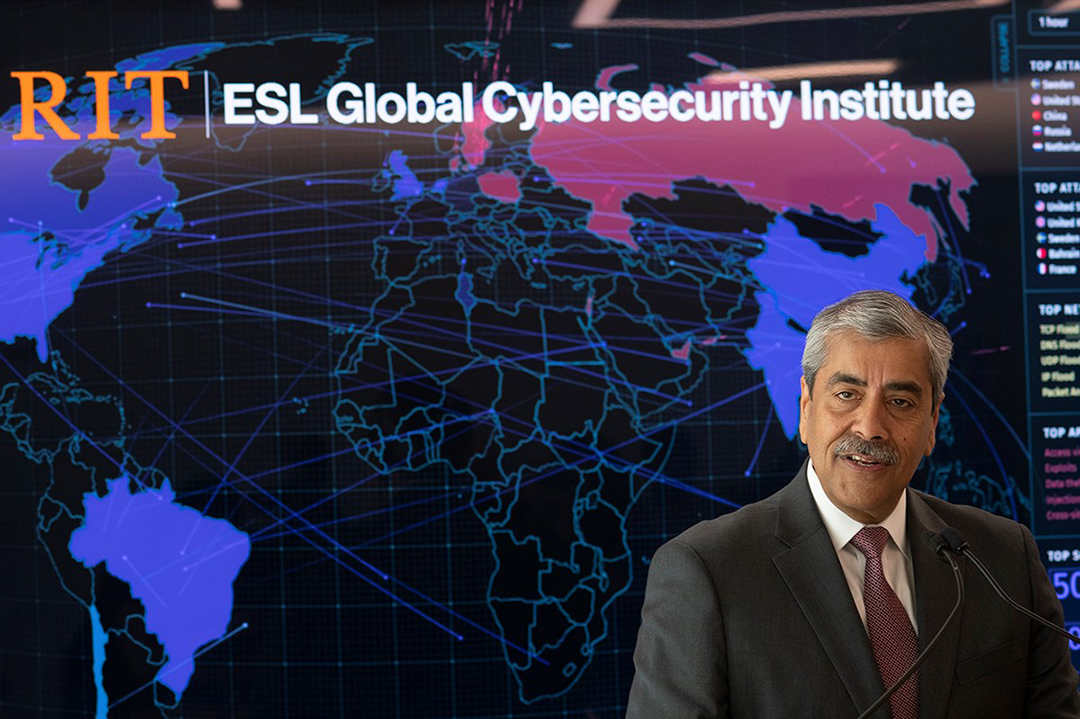 man standing in front of a map of the world with the words RIT ESL Global Cybersecurity Institute.