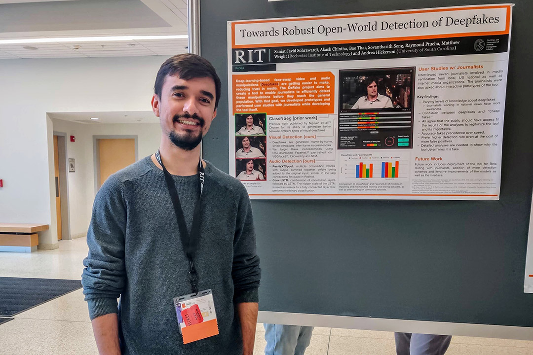 student posing with research poster.