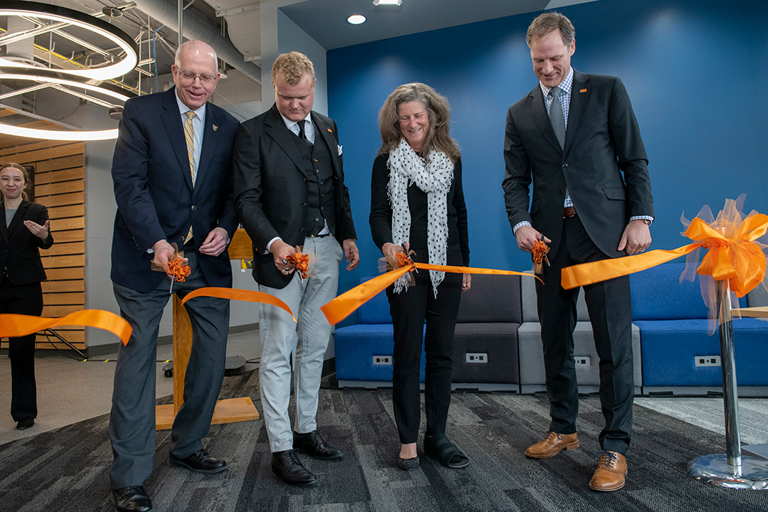 four people cutting a ceremonial ribbon.